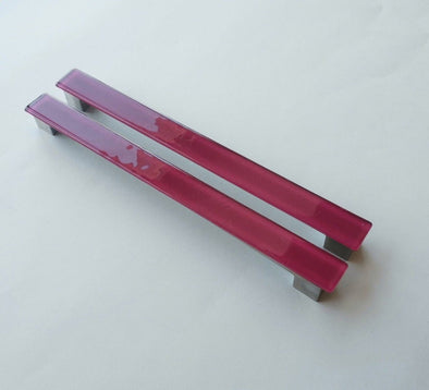 Set of two matte deep red fired glass fridge pulls made of long glass sticks attached over a silvery metal base. Slightly textured glass furniture handles with rounded edges.
