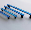 Fired glass cabinet pulls in sparkly deep blue made of fine glass sticks attached over a metal base. Slightly textured glass furniture handles with rounded edges.