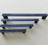 Fired glass cabinet pulls in dark indigo blue made of fine glass sticks attached over a metal base. Slightly textured glass furniture handles with rounded edges.