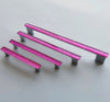 Fired glass cabinet pulls in bright pink made of fine glass sticks attached over a metal base. Slightly textured glass furniture handles with rounded edges.